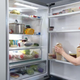Person storing food on refrigerator door